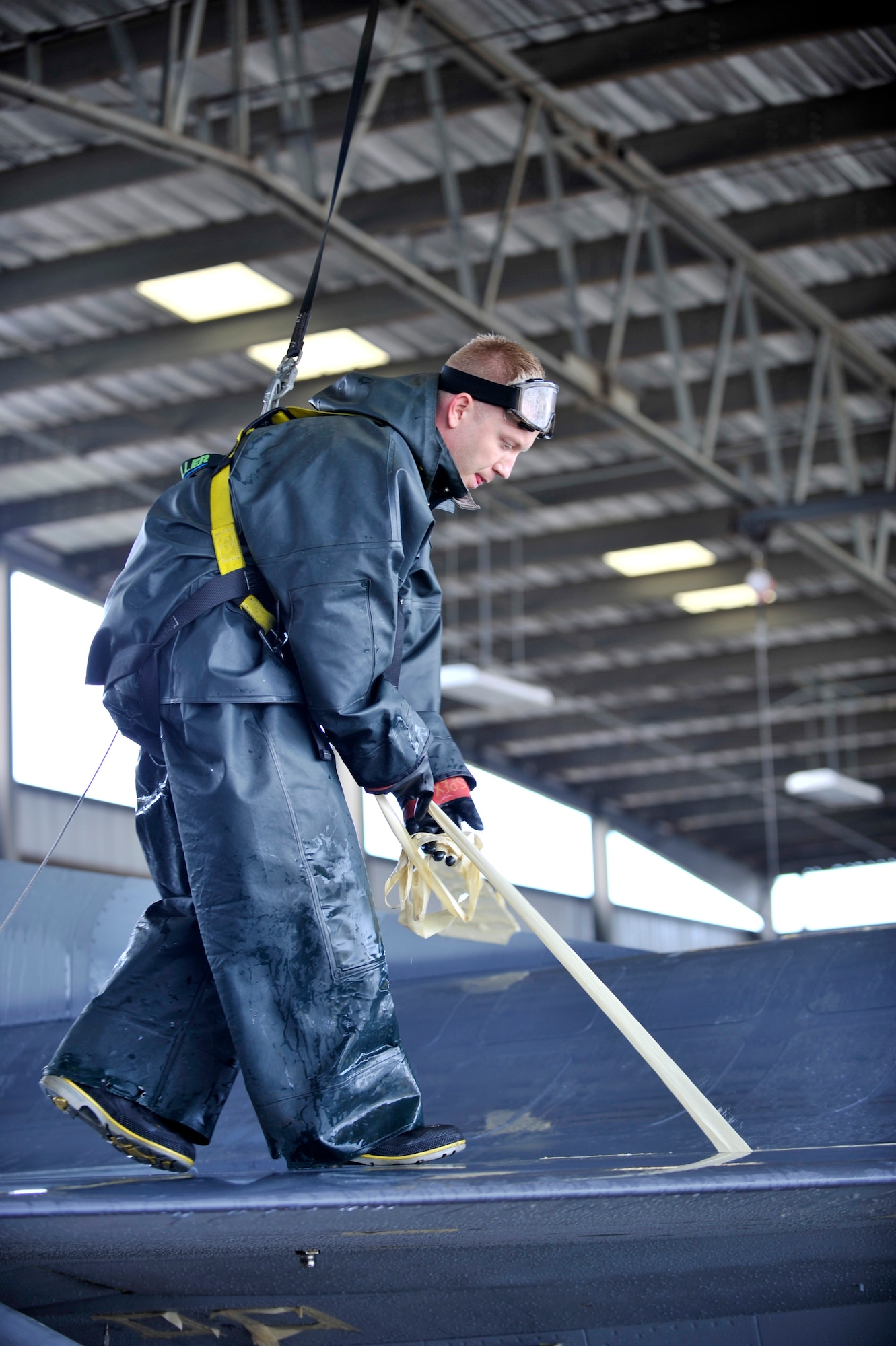 U.S. Air Force Staff Sgt. Alan Dorman, 20th Aircraft Maintenance Squadron tactical aircraft maintainer, pulls water-resistant tape off of an F-16 Fighting Falcon after a routine cleaning, Shaw Air Force Base, S.C., Oct. 28, 2013. The tape ensures that water does not get into places that could be damaged during the jets cleaning at the wash-rack. (U.S. Air Force photo by Airman 1st Class Jensen Stidham/Released)