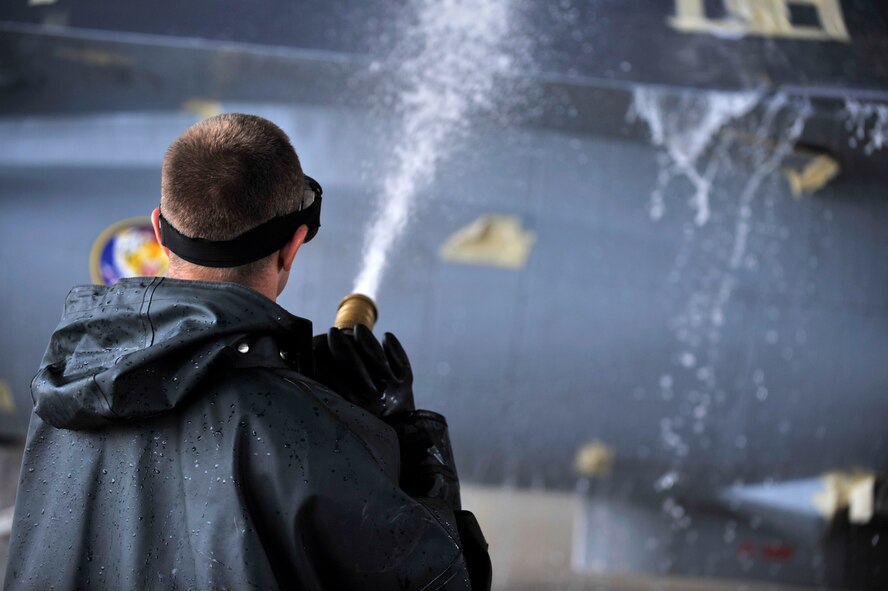U.S. Air Force Senior Airman Brad Pippin, 20th Aircraft Maintenance Squadron tactical aircraft maintainer, hoses down an F-16 Fighting Falcon during a routine cleaning, Shaw Air Force Base, S.C., Oct. 28, 2013. Pippin hosed off the soap after the jet was scrubbed from top to bottom. (U.S. Air Force photo by Airman 1st Class Jensen Stidham/Released)