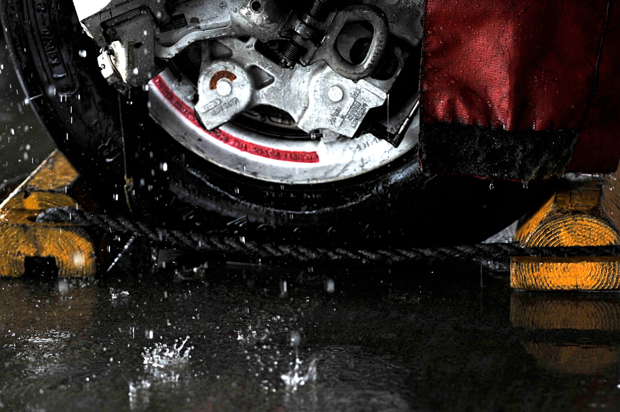 Water droplets land on the ground during a routine cleaning of an F-16 Fighting Falcon, Shaw Air Force Base, S.C., Oct. 28, 2013. No later than every 180 days, Shaw’s jets arrive at the wash-rack to be scrubbed down and washed from top to bottom. (U.S. Air Force photo by Airman 1st Class Jensen Stidham/Released)