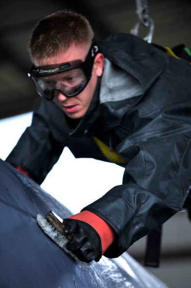 U.S. Air Force Staff Sgt. Alan Dorman, 20th Aircraft Maintenance Squadron tactical aircraft maintainer, hangs from a static line and scrubs an F-16 Fighting Falcon during a routine cleaning, Shaw Air Force Base, S.C., Oct. 28, 2013. Dorman, who was part of a three-man cleaning crew, was tasked with scrubbing the upper-half of the jet. (U.S. Air Force photo by Airman 1st Class Jensen Stidham/Released)