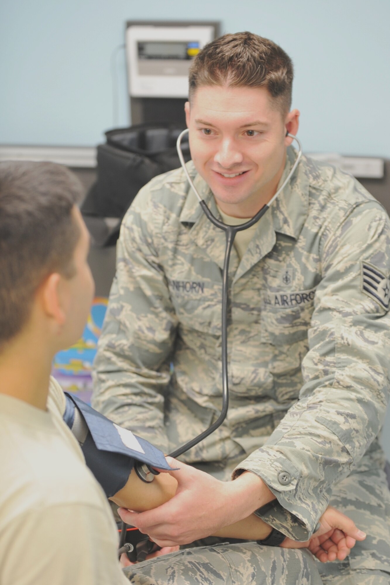 U.S. Air Force Staff Sgt. Joshua VanHorn, 65th Medical Operations Squadron medical technician, tends to a patient's blood pressure at the medical clinic on Lajes Field, Azores. VanHorn competes in car races with Portuguese local nationals in the Azores while building friendships and host nation relations within the local community. As the only U.S. participant, VanHorn displays an American flag with his last name on his rear driver's-side window. (U.S. Air Force photo by Staff Sgt. Angelique N. Smythe/Released)