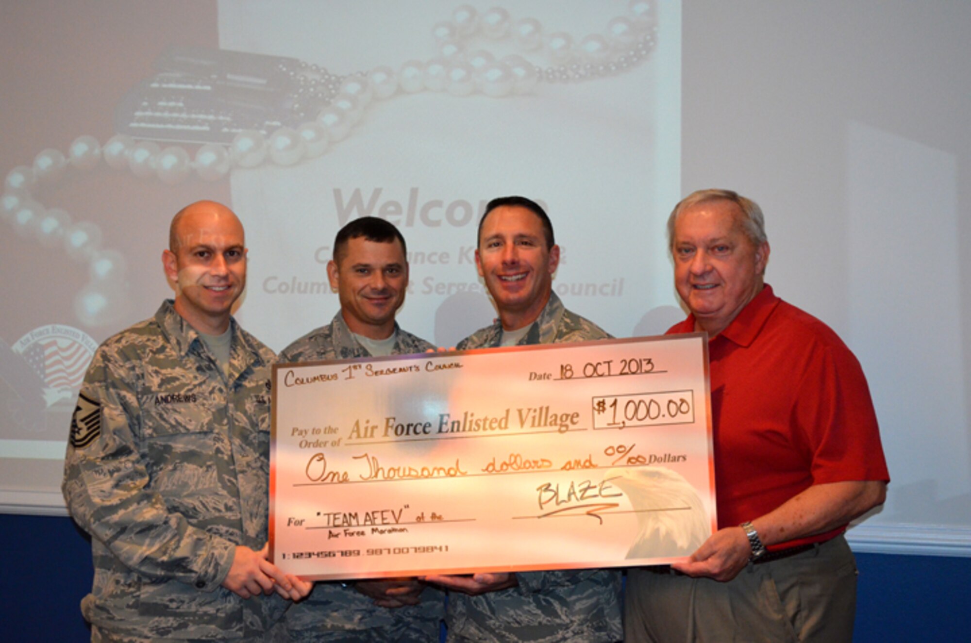The First Sergeants Council, accompanied by Chief Master Sgt. Vance Kondon, 14th Flying Training Wing Command Chief, present Jim Binnicker with a $1,000 check for the team at the Air Force Enlisted Village Oct. 18.  The AFEV provides housing and financial assistance to surviving spouses of retired Air Force personnel.  (U.S. Air Force Photo)