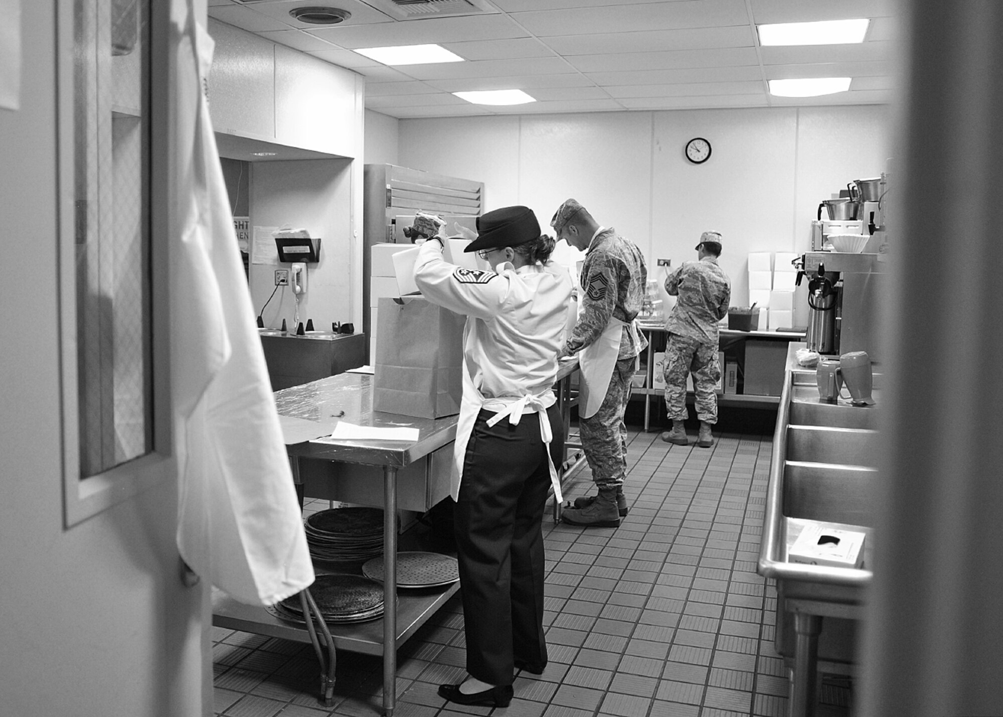 Chief Master Sgt. Wendy Hanson, 92nd Air Refueling Wing command chief, and Chief Master Sgt. Robert Mueller, 92nd Mission Support Group, assist the dining facility staff by making sandwiches for boxed lunches at Fairchild Air Force Base, Wash., Oct. 31, 2013. (U.S. Air Force photo by Senior Airman Taylor Curry/Released)
