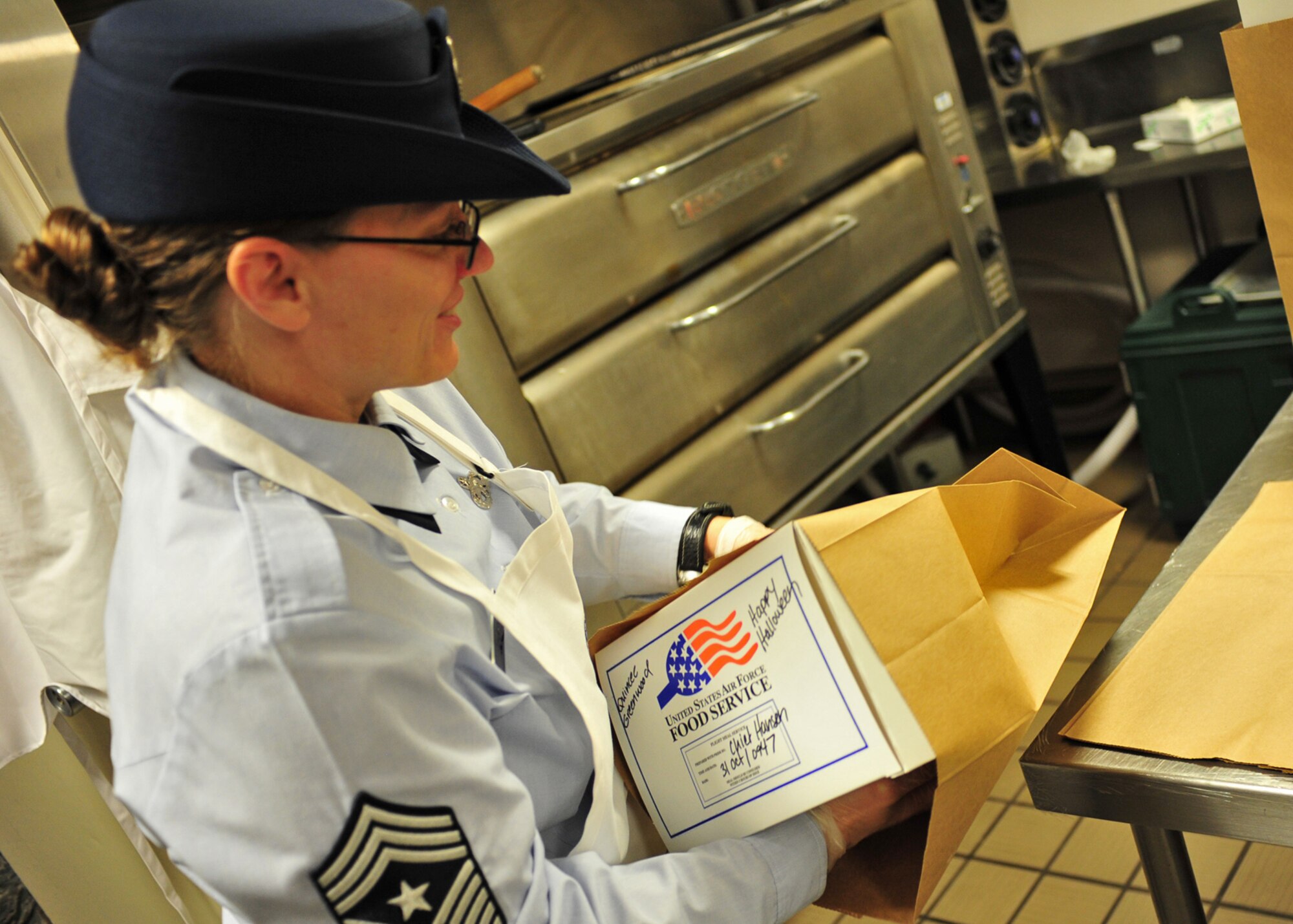 Chief Master Sgt. Wendy Hanson, 92nd Air Refueling Wing command chief, packs boxed lunches at the dining facility at Fairchild Air Force Base, Wash., Oct. 31, 2013. (U.S. Air Force photo by Senior Airman Taylor Curry/Released)