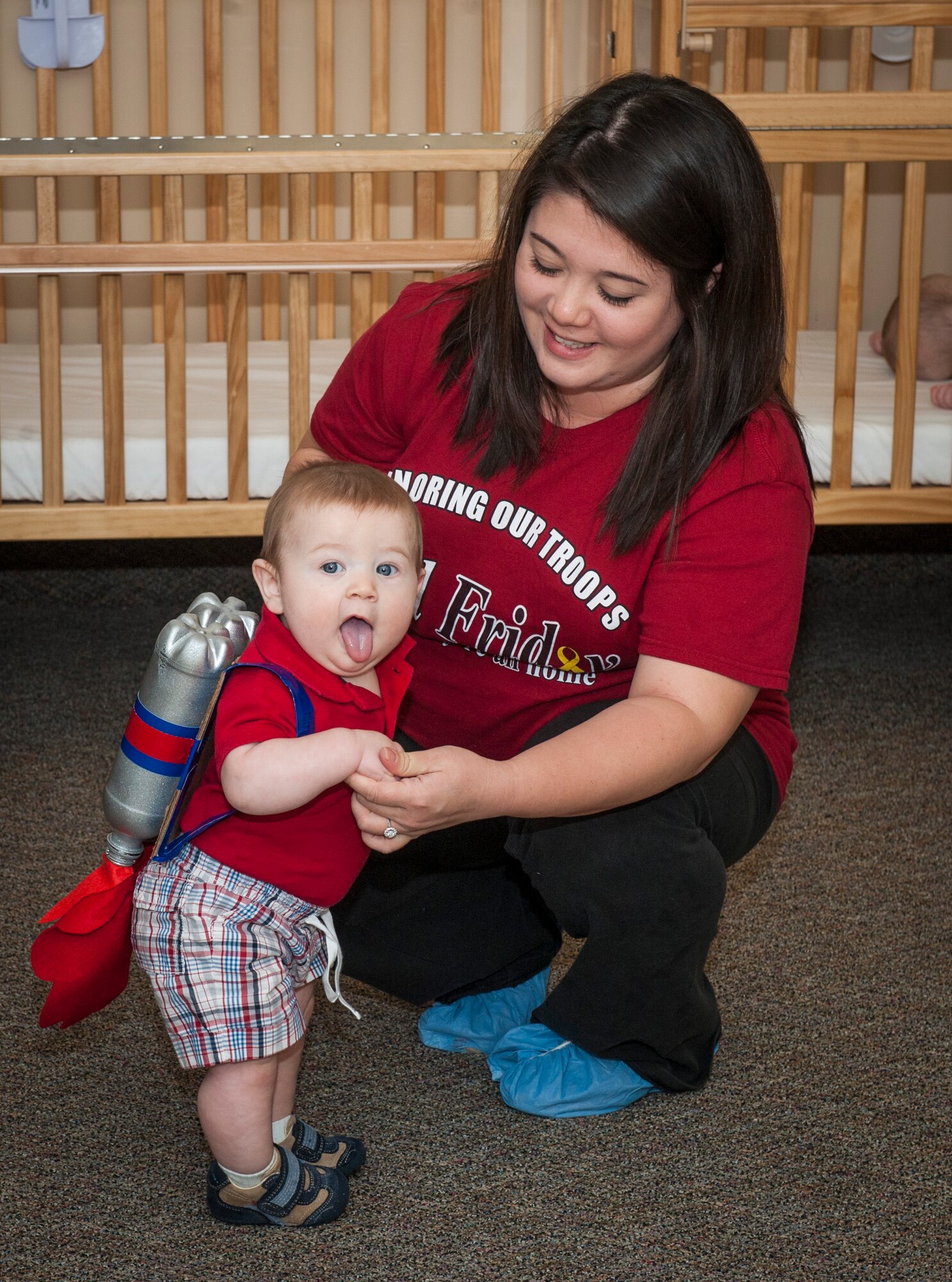 Callum Kirchoff, son of U.S. Air Force Capts. Aaron and Meredith Kirchoff, shows off his costume as Jessica Edgar, Child Development Center II caregiver, holds him during the Energy Action Month costume contest at Moody Air Force Base, Ga., Nov. 1, 2013. The three categories for the contest were most shocking, most creative and best use of recyclable materials, and Kirchoff’s costume won for most creative. (U.S. Air Force photo by Senior Airman Jarrod Grammel/Released)
