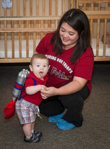 Callum Kirchoff, son of U.S. Air Force Capts. Aaron and Meredith Kirchoff, shows off his costume as Jessica Edgar, Child Development Center II caregiver, holds him during the Energy Action Month costume contest at Moody Air Force Base, Ga., Nov. 1, 2013. The three categories for the contest were most shocking, most creative and best use of recyclable materials, and Kirchoff’s costume won for most creative. (U.S. Air Force photo by Senior Airman Jarrod Grammel/Released)
