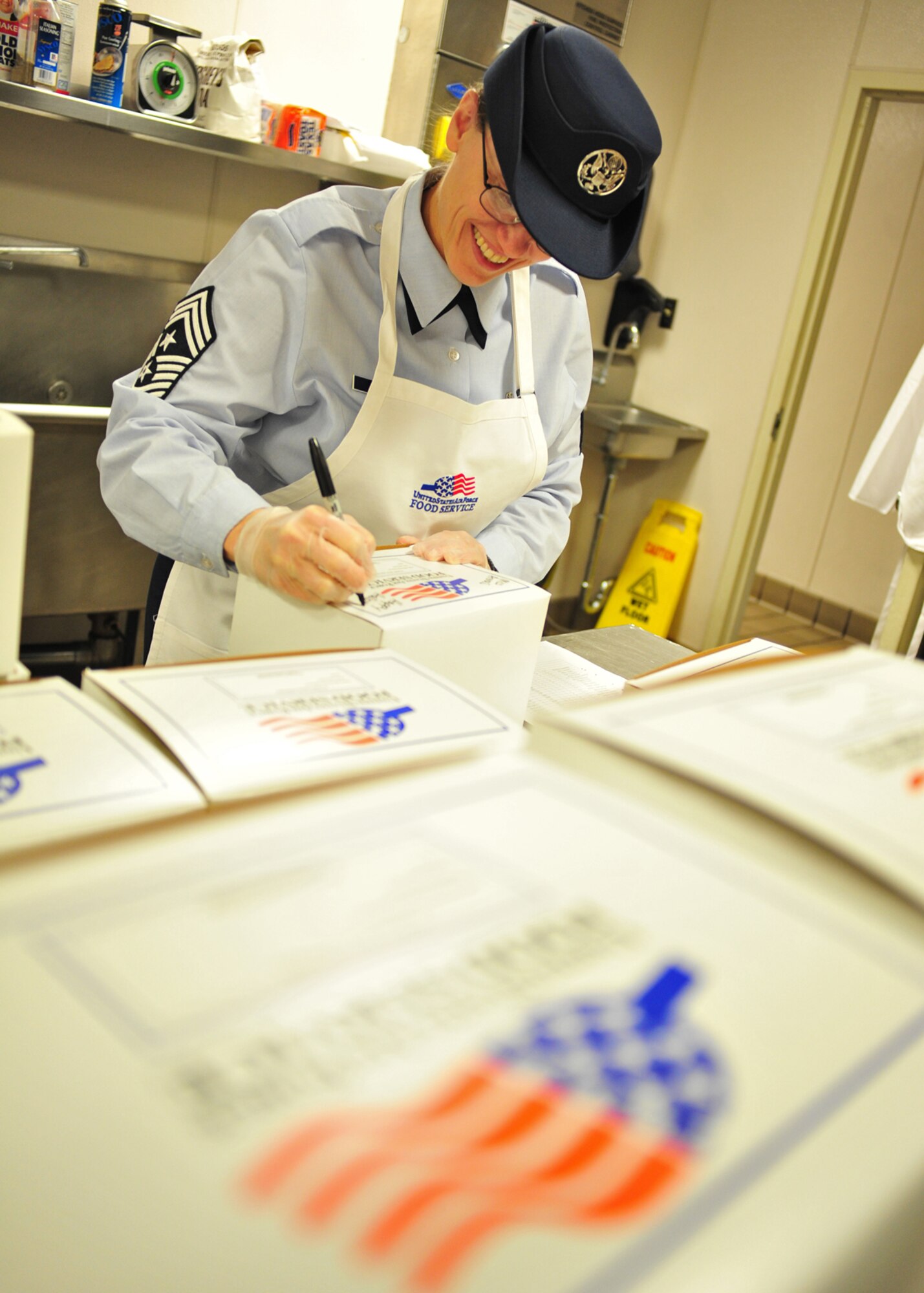 Chief Master Sgt. Wendy Hanson, 92nd Air Refueling Wing command chief, prepares boxed lunches at the dining facility at Fairchild Air Force Base, Wash., Oct. 31, 2013. (U.S. Air Force photo by Senior Airman Taylor Curry/Released)