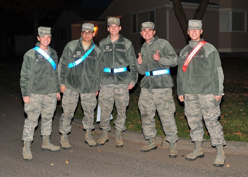 Pumpkin Patrol volunteers pose for a photo in base housing area at Fairchild Air Force Base, Wash., Oct. 31, 2013. The volunteers walked through out housing areas on base for any suspicious or criminal activities. (U.S. Air Force photo by Senior Airman Taylor Curry/Released)