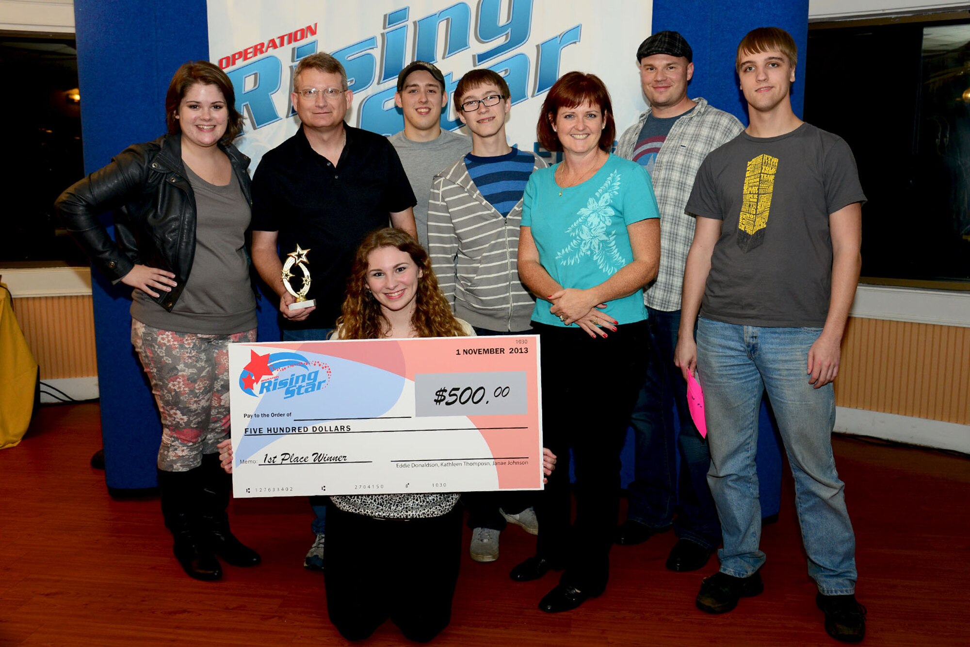 Sarah Hopkins poses with her family and friends after winning first place in the Operation Rising Star competition at Fort Eustis, Va., Nov. 1, 2013. Hopkins, whose father is a U.S. Army reservist, drove an hour from Mechanicsville each week to perform in the five-week competition. (U.S. Air Force photo by Staff Sgt. Ashley Hawkins/Released)
