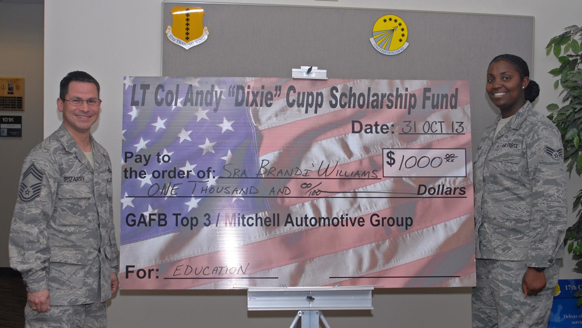 GOODFELLOW AIR FORCE BASE, Texas -- Chief Master Sgt. Raymond Irizarry, 17th Training Group superintendent, presents Senior Airman Brandì Williams, 17th Comptroller Squadron, with a scholarship check from the Lt. Col. Andy "Dixie" Cupp Scholarship Fund Oct. 31. Williams essay on why education is important to her earned her one of the two scholarships award in honor of Cupp, former 17th TRG Deputy Commander who was a strong advocate of education. (U.S. Air Force photo/ Staff Sgt. Laura R. McFarlane) 