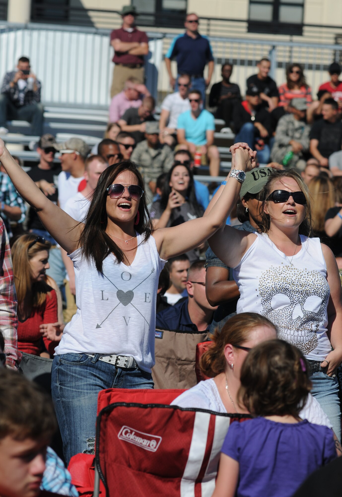 The wife of Tech. Sgt. Zachary Marshall, 334th Training Squadron, and her sister sing along with country music singer Rodney Atkins during a concert Nov. 2, 2013, at the Triangle Parade Field, Keesler Air Force Base, Miss.  Local band Autumn Rise-N also performed.  (U.S. Air Force photo by Kemberly Groue)