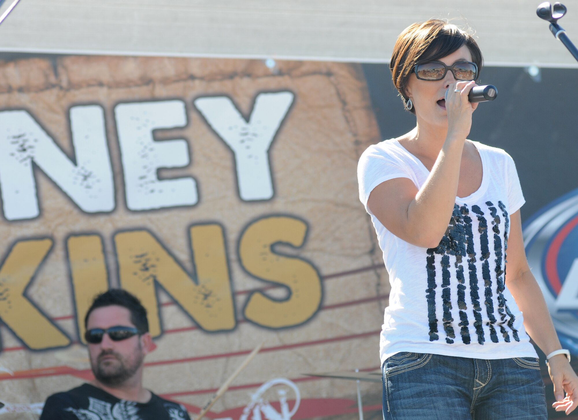 Jamie Shaw, drummer, and Ashley Hamner, vocalist for local band Autumn Rise-N performs prior to the Rodney Atkins concert Nov. 2, 2013, at the Triangle Parade Field, Keesler Air Force Base, Miss.  Airmen and Keesler personnel attended the event.   (U.S. Air Force photo by Kemberly Groue)