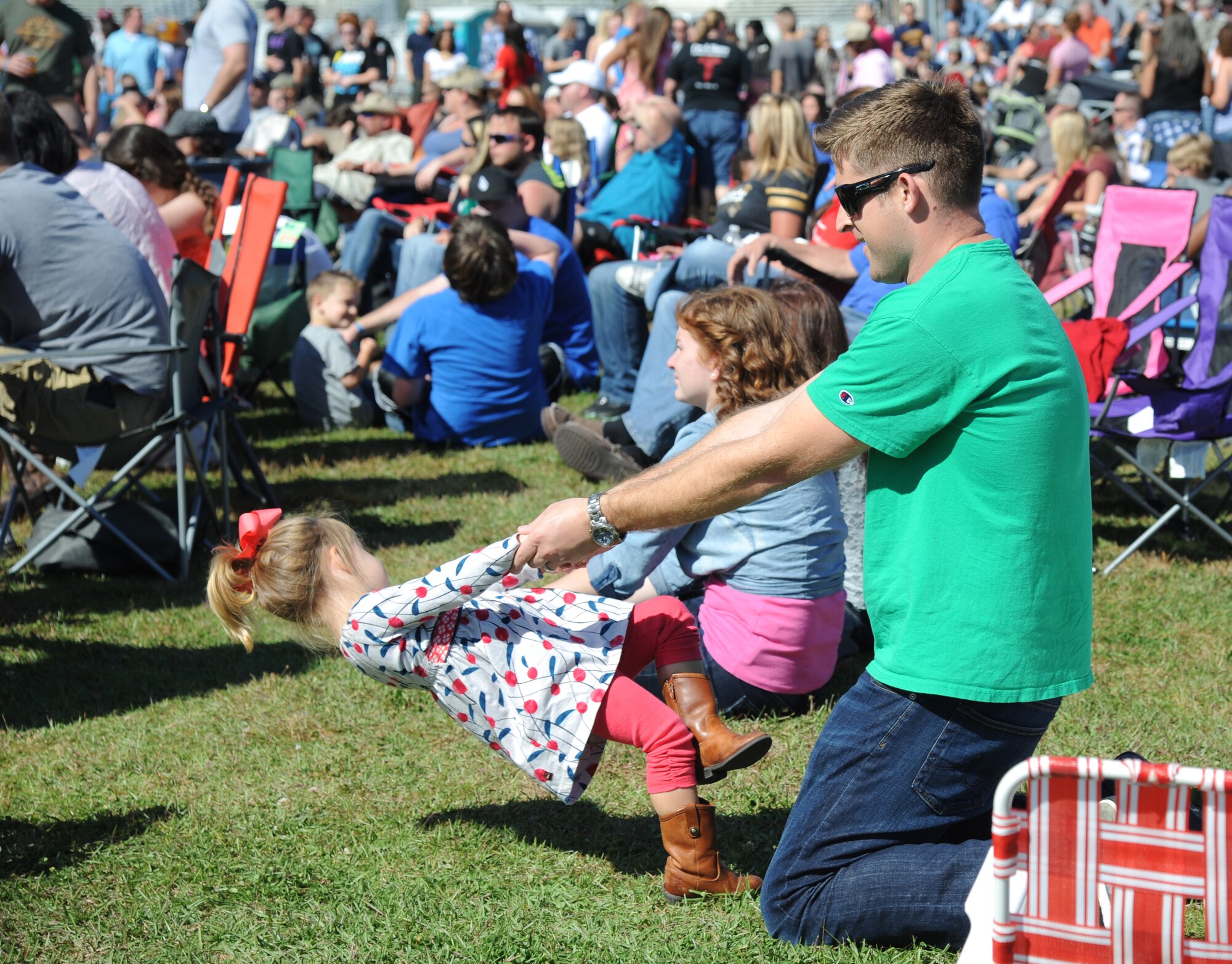 Maj. Matt Sarb, 81st Surgical Operations Squadron, dances with his daughter during a performance by local band Autumn Rise-N during a pre-show for the Rodney Atkins concert Nov. 2, 2013, at the Triangle Parade Field, Keesler Air Force Base, Miss.  Airmen and Keesler personnel attended the event.  (U.S. Air Force photo by Kemberly Groue)