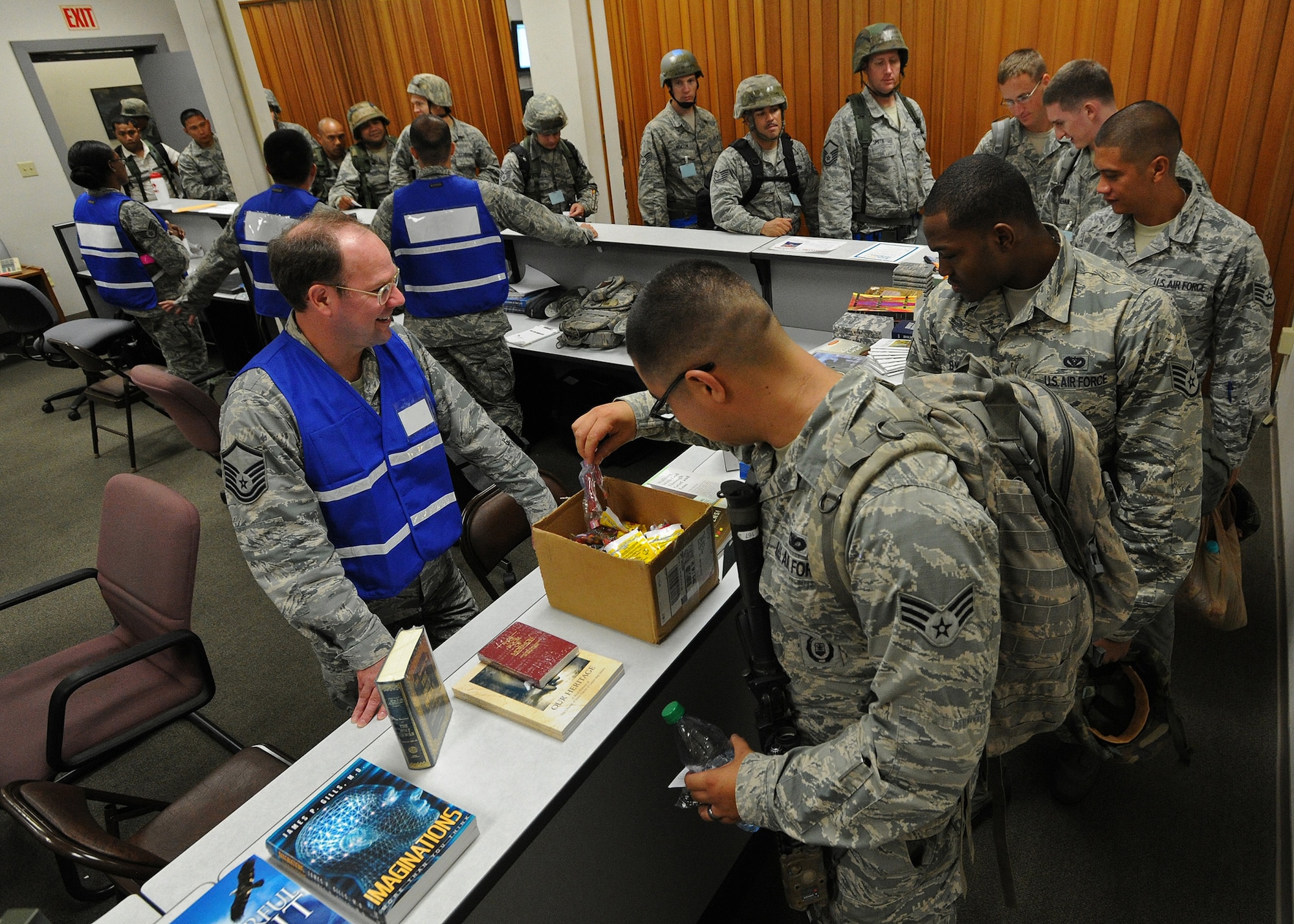 Master Sgt. Louis Bahr, 647th Air Base Group superintendent chapel operations, left, provides spiritual literature and a few of the essentials to members of the  15th Wing and 154th Wing of the Hawaii Air National Guard  at the Personnel Deployment Function building, during an Operational Readiness Inspection at Joint Base Pearl Harbor-Hickam, Hawaii, Nov. 3, 2013. The inspection evaluates their ability to perform as a cohesive Total Force Integration unit by working side-by-side to accomplish the mission during the ORI. (U.S. Air Force photo/Tech. Sgt. Jerome Tayborn) 