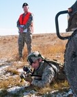 Staff Sgt. Joseph Misciagna, 791st Missile Security Forces Squadron team leader mans a defensive position under the watchful eye of a 620th Ground Combat Training Squadron instructor during a convoy protection exercise at Camp Guernsey, Wyo., Oct. 30, 2013. The Minot Air Force Base defenders were taking part in the annual exercise conducted by the 620th GCTS which train Airmen of the 20th Air Force missile wings in the defense of nuclear assets should they come under attack while being transported in convoys. (U.S. Air Force photo by R.J. Oriez) 