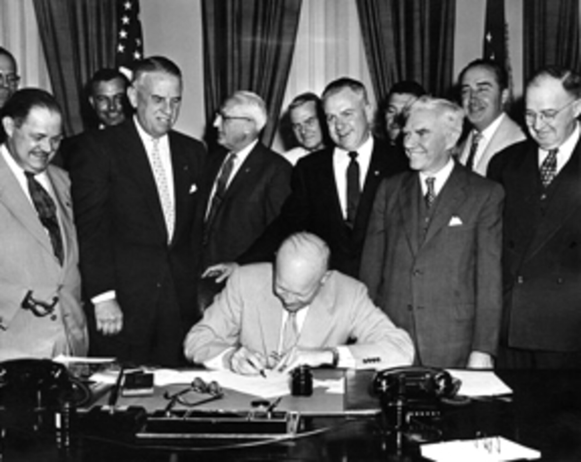 (Center) President Dwight D. Eisenhower signs HR7786, changing Armistice Day to Veterans Day. With the approval of Public Law 380 on June 1, 1954, November 11 became a day to honor American veterans of all wars. (Photo courtesy of U.S. Department of Veterans Affairs)