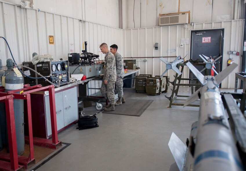 U.S. Air Force Airmen 1st Class Cameron Veazey, left, and Adolfo de la Cruz, 23d Equipment Maintenance Squadron precision guided munitions crew members, perform a functional test of an AIM-9 Sidewinder missile head at Moody Air Force Base, Ga., Oct. 31, 2013. The test checks the functionality of the missile’s tracking system. (U.S. Air Force photo by Airman 1st Class Sandra Marrero/Released)
