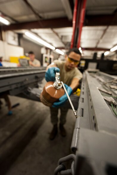 U.S. Air Force Airman 1st Class Barron English, 23d Equipment Maintenance Squadron equipment maintenance crew chief, oils an MHU-141/M munitions trailer at Moody Air Force Base, Ga., Oct. 31, 2013. Oiling the vehicle prevents wear from moving metal-to-metal parts, which helps ensure the safe transportation of munitions.  (U.S. Air Force photo by Airman 1st Class Sandra Marrero/Released)

