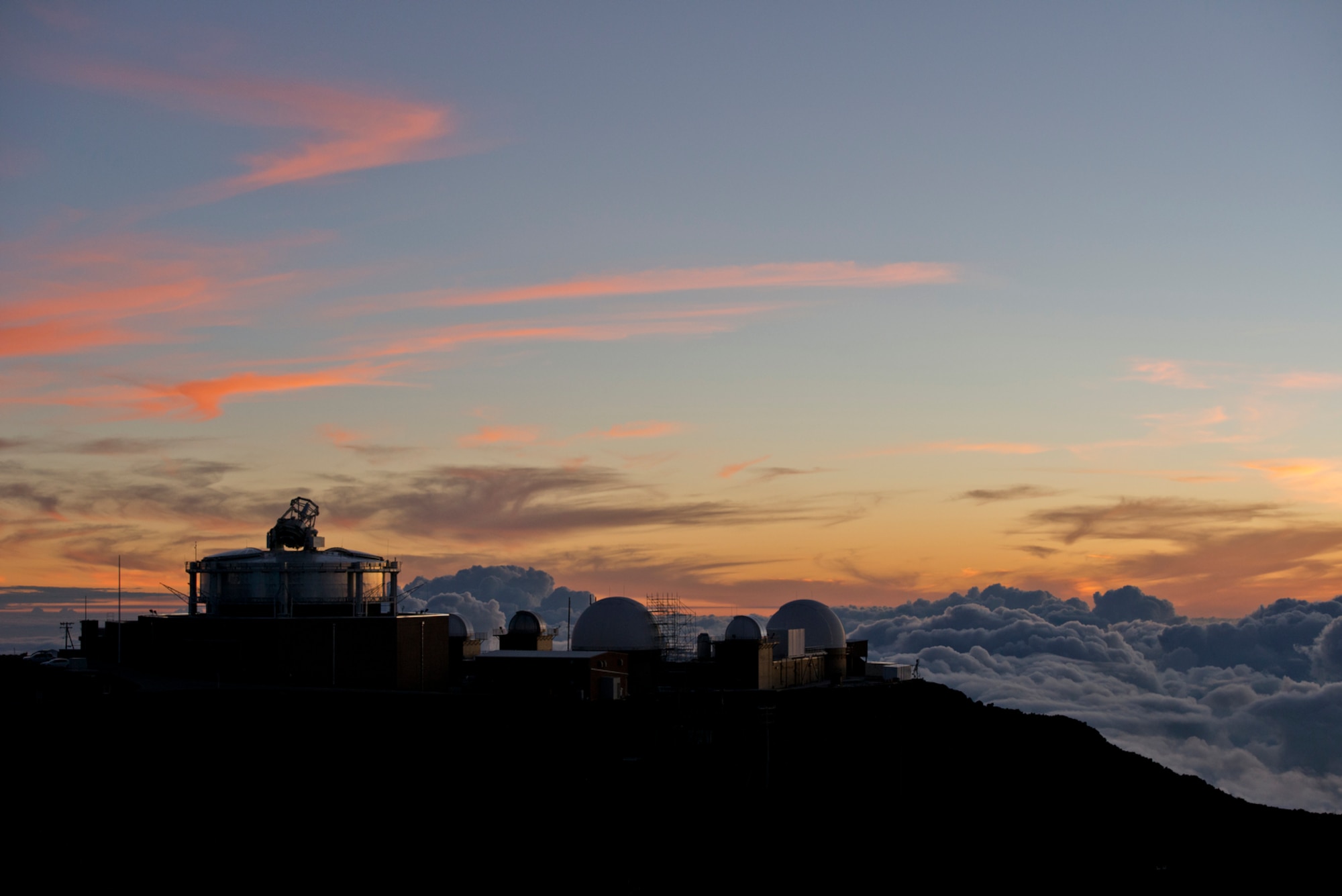 A sunset view of Maui Space Surveillance System on Mount Haleakala, above the clouds at 10,000 feet. Clear visibility and location near the equator, makes Haleakala a very stable environmental for viewing space. (U.S. Air Force photo/Tech. Sgt. Bennie J. Davis III)