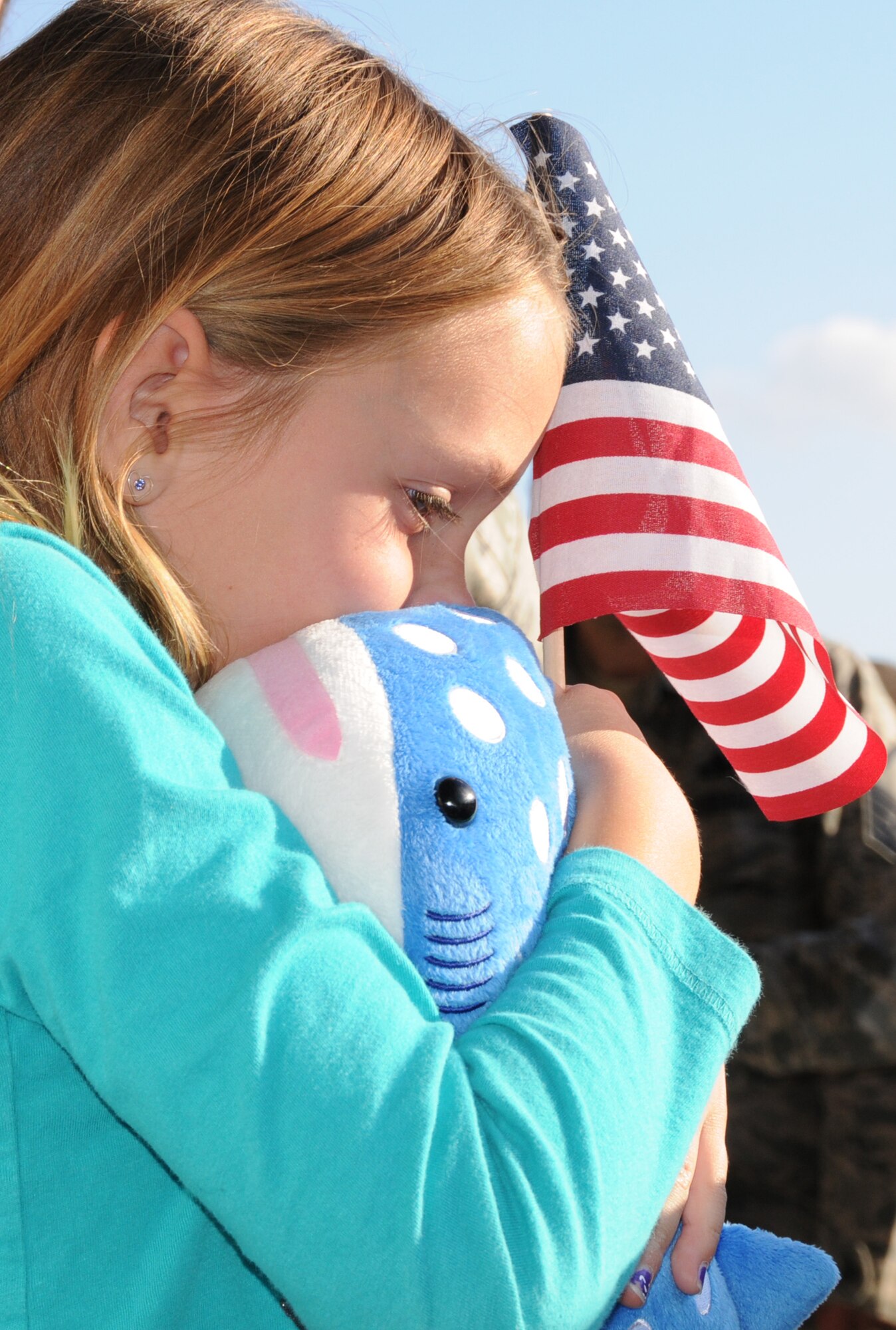 Anna Joyce, 8-year-old daughter of U.S. Air Force Senior Master Sgt. William K. Joyce, 192D Fighter Wing aircraft maintenance superintendent, squeezes a toy her father gave her following his deployment to Kadena Air base, Japan, October 23, 2013.  More than 200 Airmen from 192D Fighter Wing and the 27th Fighter Squadron were outfitted with the F-22 Raptor and assigned to the U.S. Pacific Command as part of a Theater Security Package rotation.  TSP deployments provide stability and security while allowing units to integrate with U.S. and Japanese forces. (U.S. Air National Guard photo by Master Sgt. Carlos J. Claudio/Released)