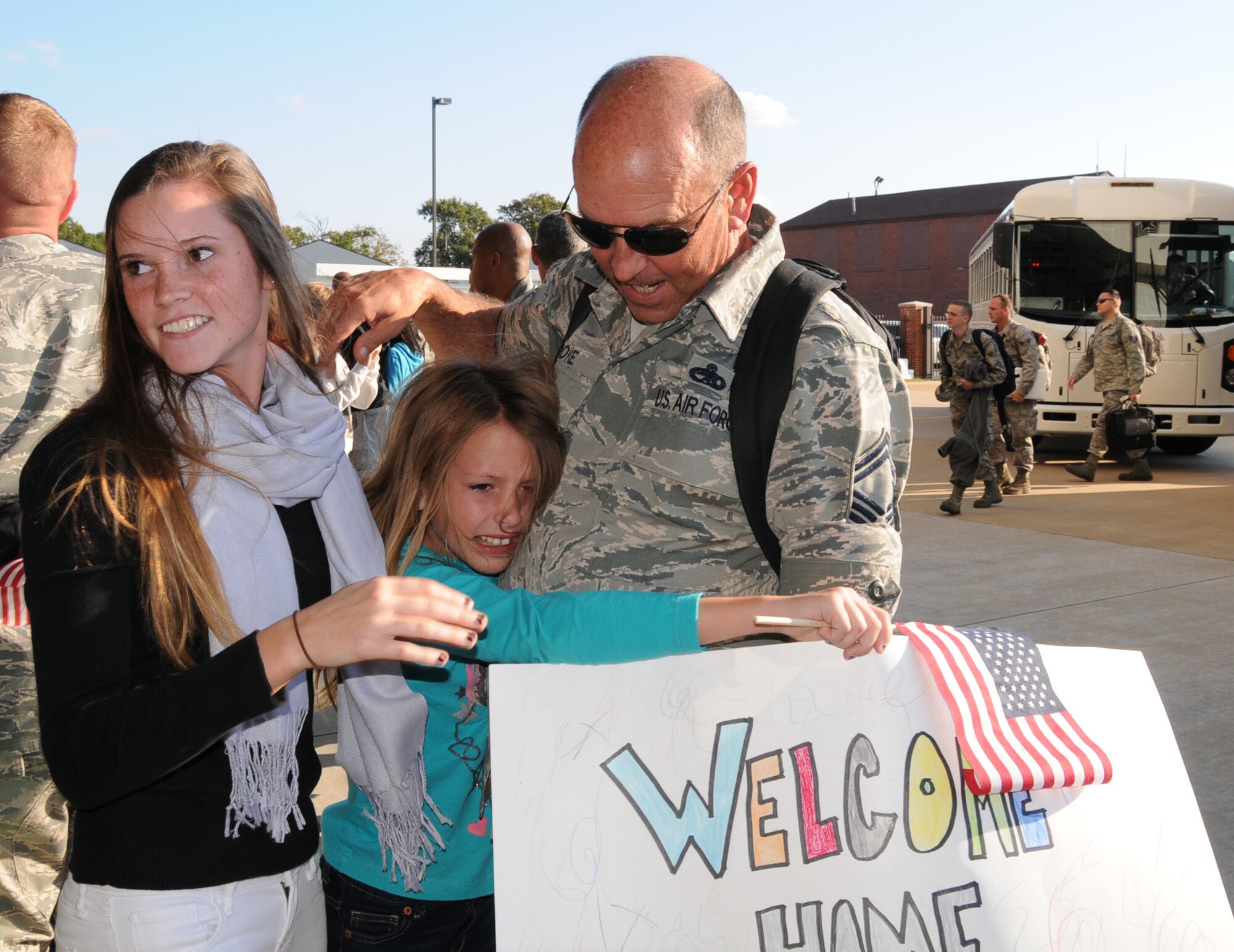 Anna Joyce (center) gives an emotional hug to her father, U.S. Air Force Senior Master Sgt. William K. Joyce, 192D Fighter Wing aircraft maintenance superintendent, as her sister Ellen (left) looks for their mother to join in, October 23, 2013.  After nearly a six-month deployment to Kadena Air Base, Japan, more than 200 Airmen from 192D Fighter Wing and the 27th Fighter Squadron outfitted with the F-22 Raptor, were assigned to the U.S. Pacific Command as part of a Theater Security Package rotation.   TSP deployments provide stability and security while allowing units to integrate with U.S. and Japanese forces. (U.S. Air National Guard photo by Master Sgt. Carlos J. Claudio/Released)