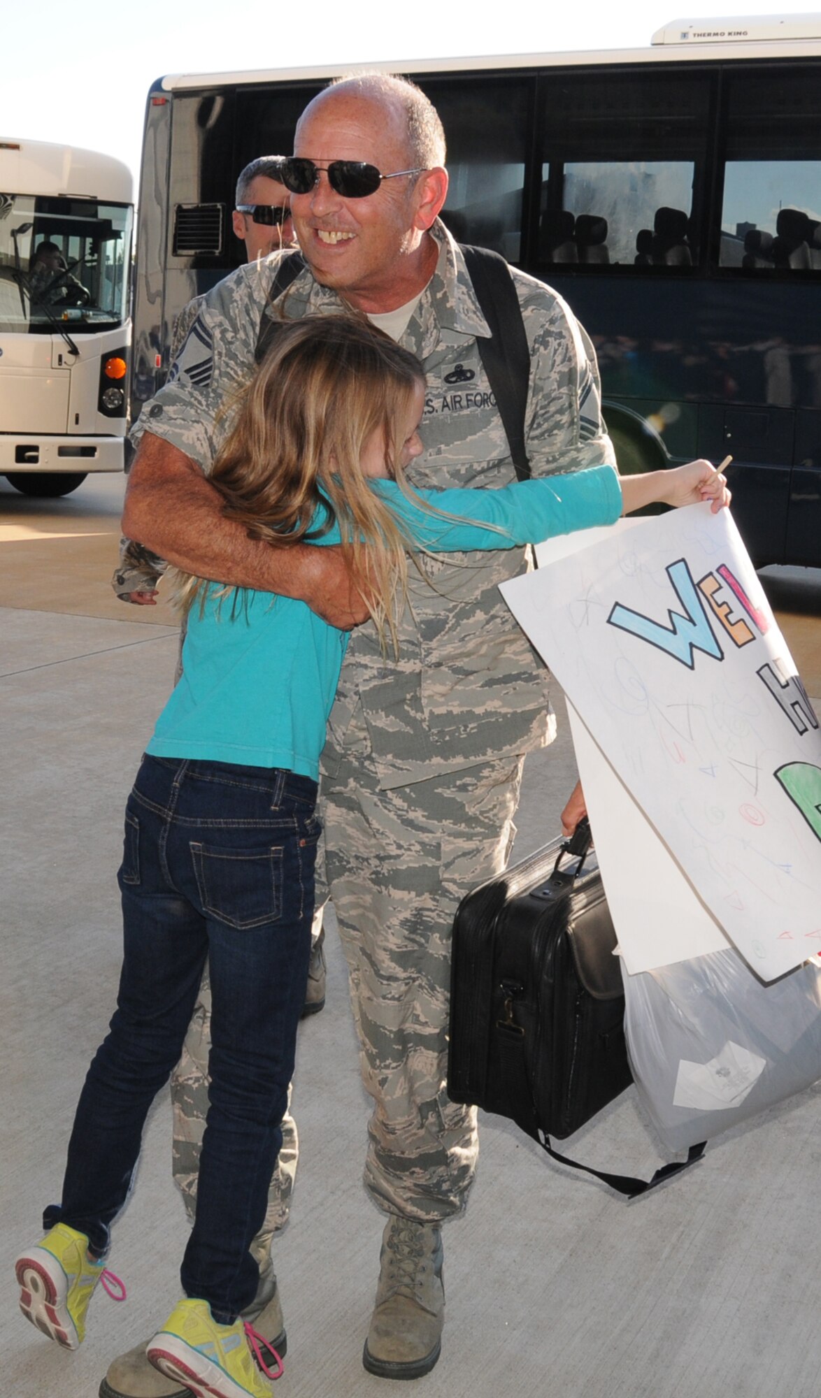 Without giving him an opportunity to put his bags down, Anna Joyce, 8, charges her father, U.S. Air Force Senior Master Sgt. William K. Joyce, 192D Fighter Wing aircraft maintenance superintendent, and gives him an unmistakable hug, October 23, 2013.  After nearly a six-month deployment to Kadena Air Base, Japan, more than 200 Airmen from 192D Fighter Wing and the 27th Fighter Squadron outfitted with the F-22 Raptor, were assigned to the U.S. Pacific Command as part of a Theater Security Package rotation.   TSP deployments provide stability and security while allowing units to integrate with U.S. and Japanese forces. (U.S. Air National Guard photo by Master Sgt. Carlos J. Claudio/Released)