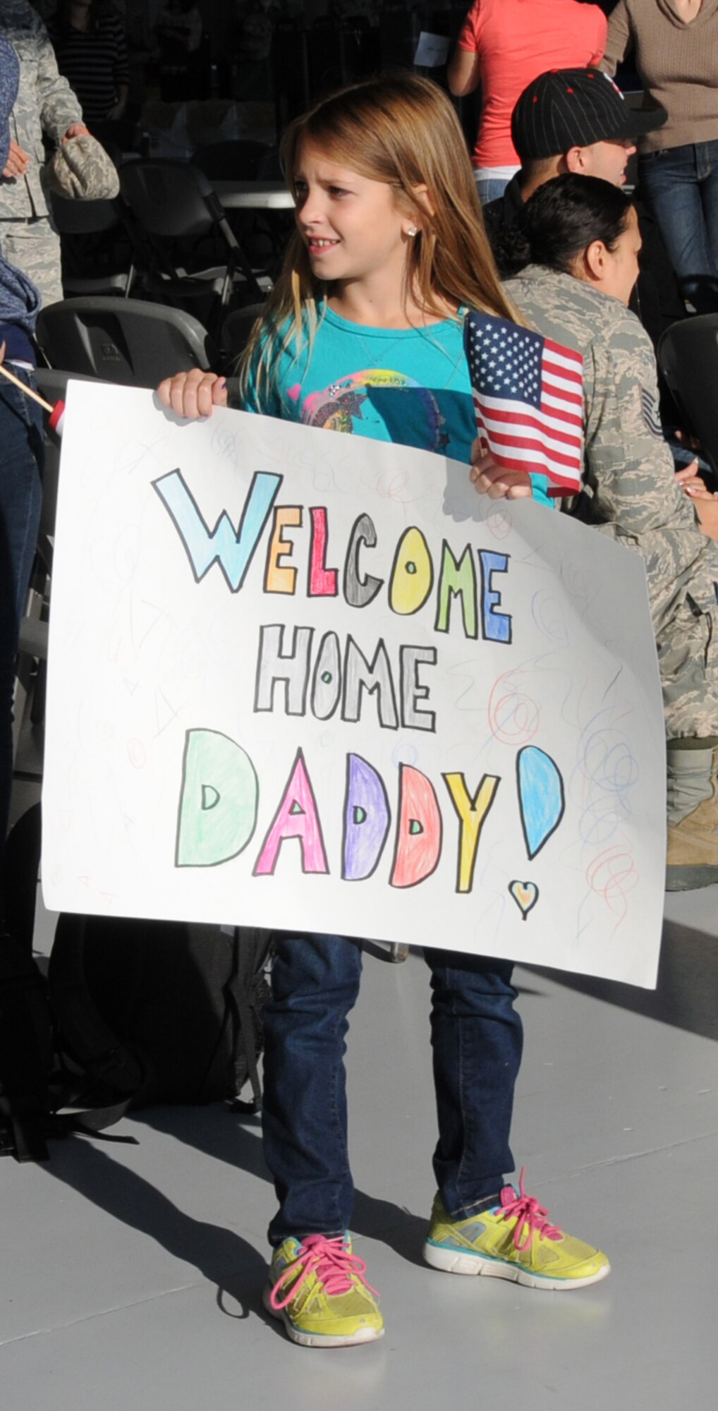 Anna Joyce, 8-year-old daughter of U.S. Air Force Senior Master Sgt. William K. Joyce, 192D Fighter Wing Maintenance Superintendent, waits patiently for the bus bringing her father to the hangar to reunite after his deployment to deployment to Kadena Air Base, Japan, October 23, 2013.  More than 200 Airmen from the 192D Fighter Wing and the 27th Fighter Squadron outfitted with the F-22 Raptor, were assigned to the U.S. Pacific Command as part of a Theater Security Package rotation.  TSP deployments provide stability and security while allowing units to integrate with U.S. and Japanese forces. (U.S. Air National Guard photo by Master Sgt. Carlos J. Claudio/Released)