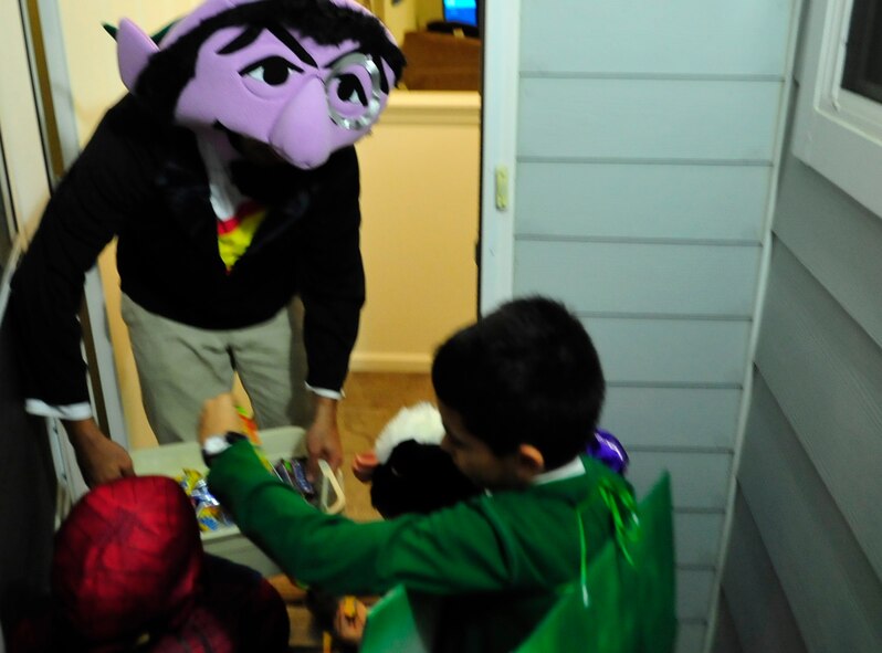 Trick-or-treaters get candy from a base resident dressed as  Count Von Count Oct. 31, 2013, at Dover Air Force Base, Del. Residents in base housing dressed up to hand out candy to trick-or-treaters. (U.S. Air Force photo/Airman 1st Class William Johnson)