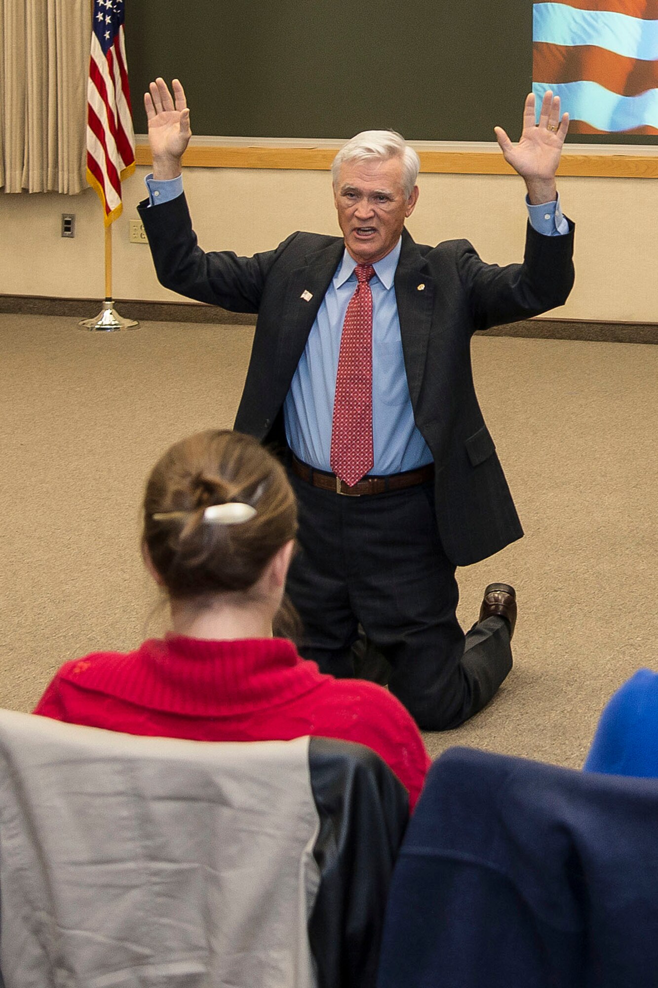 HANSCOM AIR FORCE BASE, Mass. – Retired Lt. Col. Barry Bridger demonstrates to a large crowd at the Hanscom Conference Center a form of torture he endured while a prisoner of war in Vietnam during the Heritage of Freedom speaker series, Oct. 24. Colonel Bridger spoke about his six years in captivity as a prisoner of war at the “Hanoi Hilton” and also offered advice to today’s Airmen. (U.S. Air Force photo by Walter Santos)