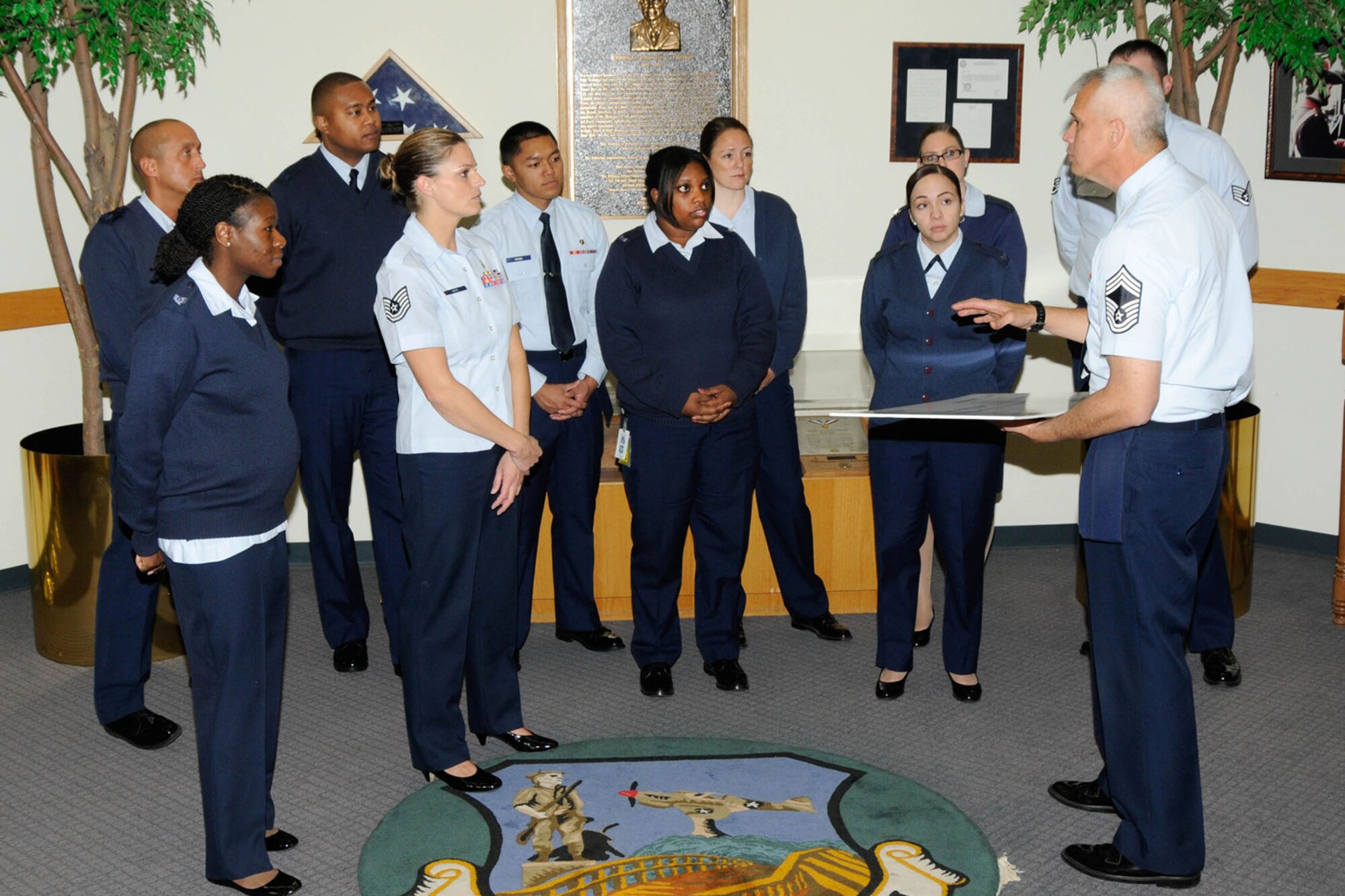 HANSCOM AIR FORCE BASE, Mass. – Chief Master Sgt. Mitchell K. Balutski (right), Hanscom Air Force Base senior enlisted advisor, accepts a $650 check from Tech. Sgt. Kristin Hays (center without sweater) and other members of the enlisted community in the Brown Building lobby, Oct. 28. Network 5/6, a Hanscom professional organization comprised of staff sergeants and technical sergeants, sponsored a Hanscom Flea Market that was held Sept. 21 with all proceeds benefitting the Air Force Enlisted Village. (U.S. Air Force photo by Linda LaBonte Britt)