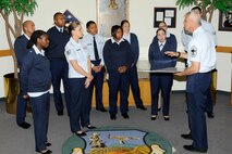 HANSCOM AIR FORCE BASE, Mass. – Chief Master Sgt. Mitchell K. Balutski (right), Hanscom Air Force Base senior enlisted advisor, accepts a $650 check from Tech. Sgt. Kristin Hays (center without sweater) and other members of the enlisted community in the Brown Building lobby, Oct. 28. Network 5/6, a Hanscom professional organization comprised of staff sergeants and technical sergeants, sponsored a Hanscom Flea Market that was held Sept. 21 with all proceeds benefitting the Air Force Enlisted Village. (U.S. Air Force photo by Linda LaBonte Britt)