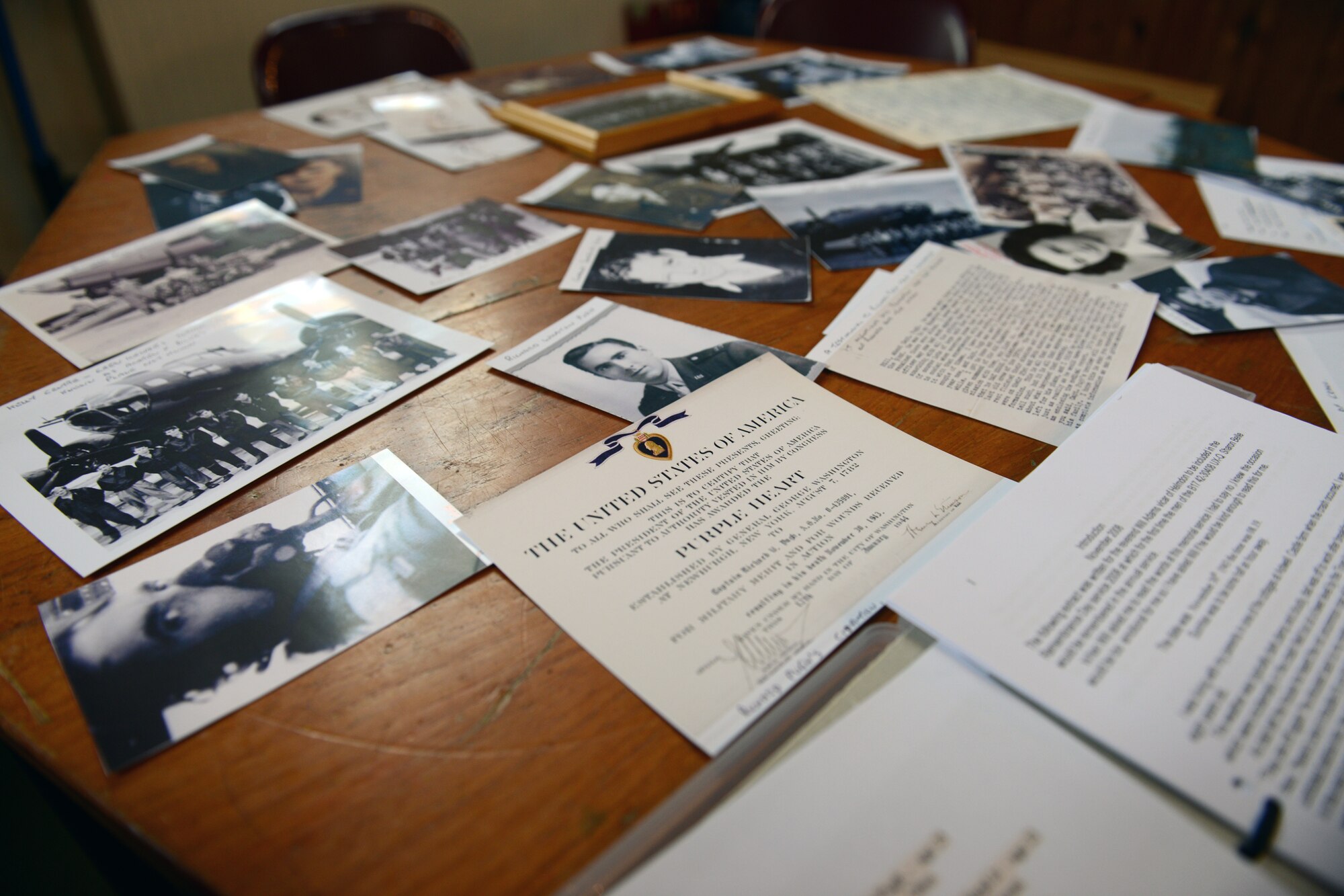 HELMDON, United Kingdom – Old photos and documents sits on a table in the Parish Church of St. Mary Magdalene in Helmdon Nov. 2. The village and 422nd Air Base Group held a ceremony in honor of the 327th Bombardment Squadron, VIII Bomber Command, Airmen killed Nov. 30, 1943, when they left RAF Poddington on a bombing mission to Germany, and their plane crashed at Astwell Castle Farms. (U.S. Air Force photo by Tech. Sgt. Chrissy Best)