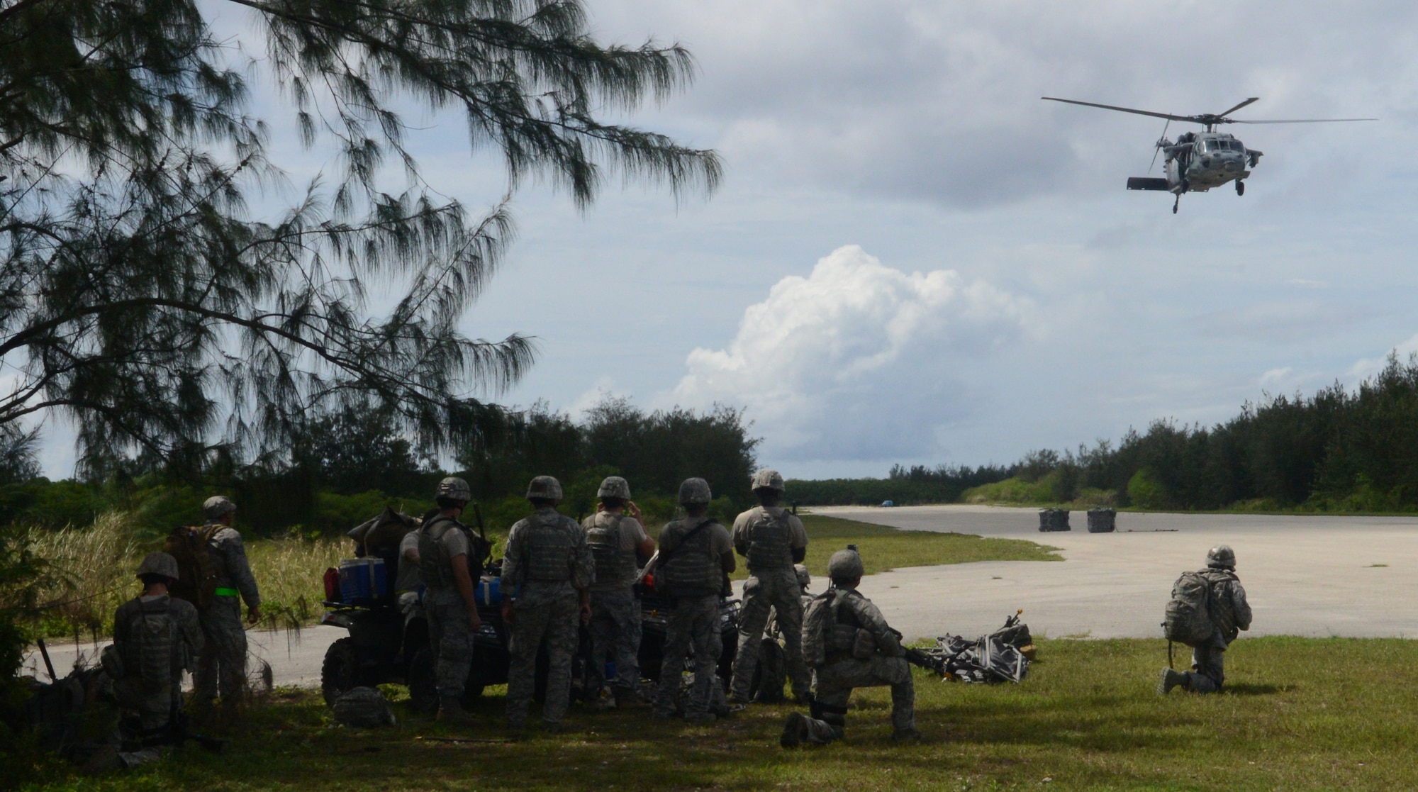 Airmen from the 36th Civil Engineer Squadron, 36th Mobility Response Squadron and 736th Security Forces Squadron watch as a helicopter crew drops a sling load during a training exercise Oct. 29, 2013, on Naval Base Guam. The scenario was designed to test the Airmen’s ability to secure and assess a potentially hostile airstrip’s suitability for follow-on Department of Defense aircraft. (U.S. Air Force photo by Airman 1st Class Emily A. Bradley/Released)