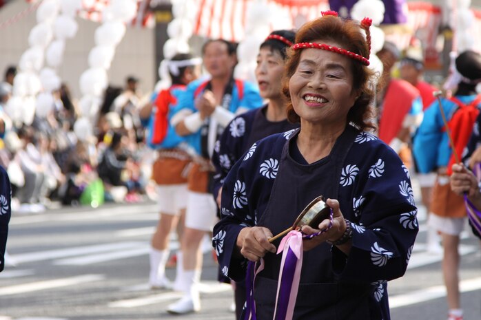 A performer smiles during the parade at the 55th annual Iwakuni Festival Oct. 16 held in downtown Iwakuni. The parade occupied the road with approximately 700 performers under 14 groups from Iwakuni city hall, JMSDF and local businesses. To accommodate the festival approximately 400 meters from Route 188 was closed to vehicle traffic.