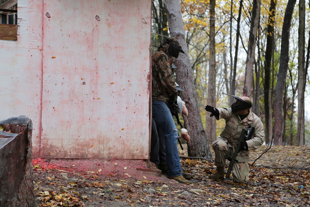 U.S. Marine Corps Staff Sgt. Michael Pena, right, kneels down while giving orders to future recruits in his Delayed Entry Program during a pool function at Hell Survivors, a paintball range in Pinckney, Mich., Nov. 2, 2013. Pena is the staff noncommissioned officer in charge of Recruiting Sub-Station Ypsilanti, Mich. He uses paintball as a fun way of instilling camaraderie and teamwork into his future Marines. (U.S. Marine Corps photo by Sgt. Elyssa Quesada/Released)