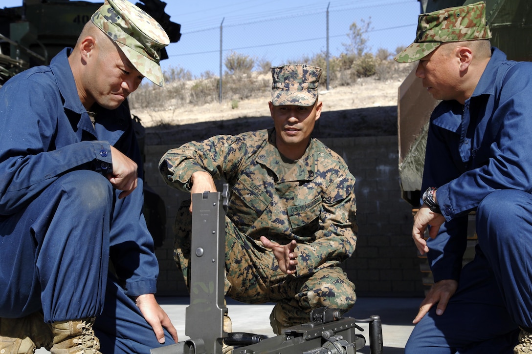 Staff Sgt. Alejandro Lopez teaches Sgt. 1st Class Yoji Yamaguchi and Master Sgt. Yasushi Yamakawa how to assemble a .50 caliber machine gun during the Amphibious Assault Crewman Course Nov. 5. Members of the Japanese Ground Self-Defense Force are training with Marines as part of the Military Sales Program. Yamaguchi and Yamakawa are both members of the JGSDF and are currently students in the AAC Course. Lopez is the instructor of the AAC Course.