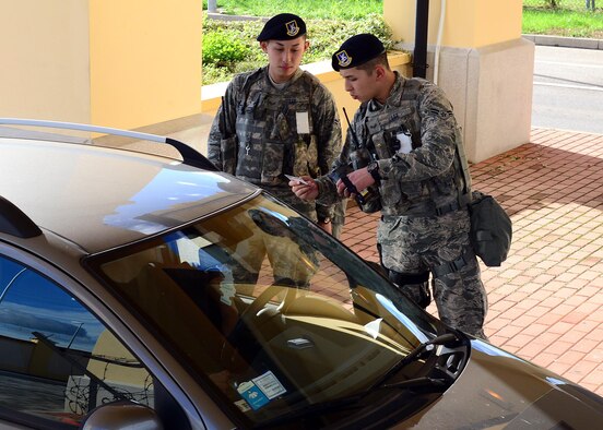 Airmen 1st Class Ja and Woo Lee check a service member’s identification card Nov. 5, 2013, at Aviano Air Base, Italy. The 20 year-old identical twins are from Fresno, Calif. and arrived at here Aug. 10, 2013. Both of them are 31st Security Forces Squadron defenders 