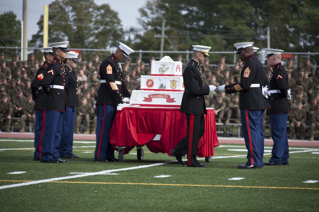 U.S. Marine Corps Brig. Gen. Robert F. Castellvi, center, commanding general, Marine Corps Installations East, passes a piece of cake to the oldest Marine present, right, during the Joint Daytime Ceremony aboard Camp Lejeune, N.C., Nov. 6, 2013. The ceremony is held every year in honor of the Marine Corps birthday. (U.S. Marine Corps photo by Lance Cpl. Andre Dakis, COMCAM, MCI-East, Camp Lejeune/Released)