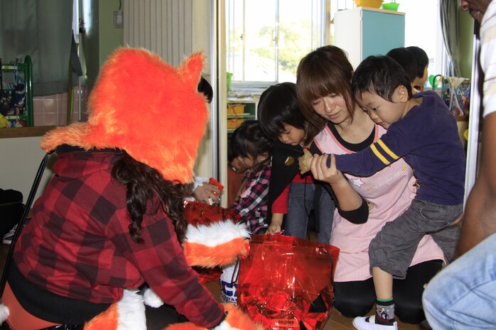 A child stares at a bag of candy at Midoro Hoiken school Oct. 27. Volunteers helped teach the children about Halloween.Eight years ago, Noriko Yamada, station chapel administration specialist, started these monthly visits to Midoro. Volunteers bought the candy they gave to the children using their own money.