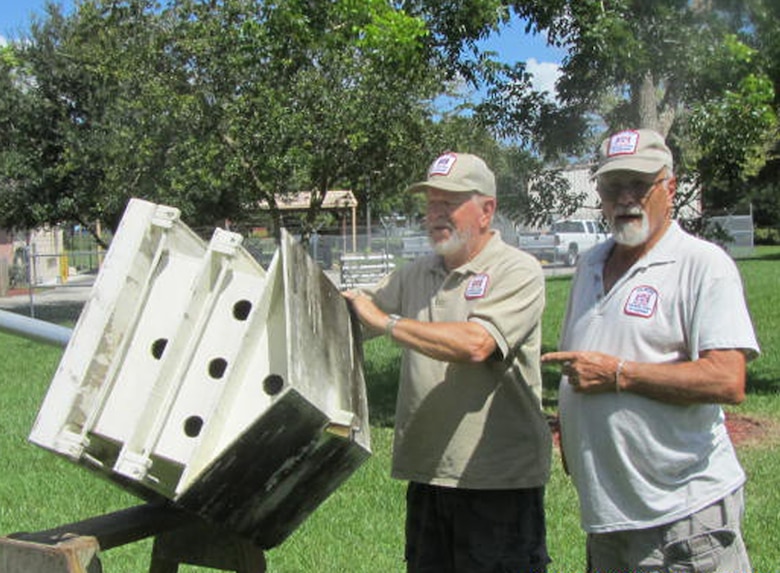 W.P. Franklin Lock and Dam Recreation Area volunteers Don Chapman (left) and George Schisler clean and repair one of the many Purple Martin “palaces” that they have built over the years, in preparation for the return of Purple Martin colonies in January.
