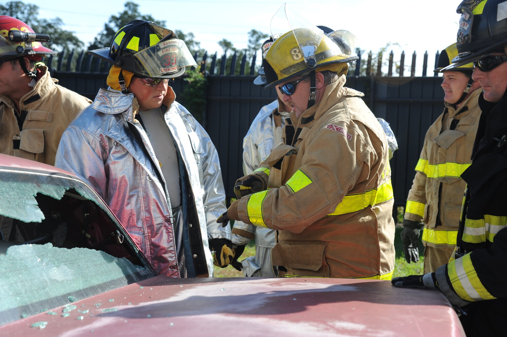 Staff Sgt. Jared Lott, Keesler firefighter, and John Massey, Biloxi firefighter, discuss proper ways to remove vehicle windows during a two-day joint auto extrication training with the next generation of battery powered jaws of life equipment Nov. 5, 2013, at Keesler Air Force Base, Miss.  Keesler and Biloxi Fire Departments conduct several joint training sessions a year to include: live fire structural burn, auto and a variety of other classes.  (U.S. Air Force photo by Kemberly Groue)