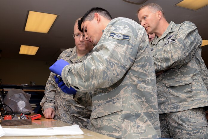 Airmen 1st Class Kasey Ray, 437th Maintenance Squadron Precision Measurement Equipment Laboratory technician, gives Col. Jeff DeVore, Joint Base Charleston commander, and Col. Darren Hartford, 437th Airlift Wing commander, a brief synopsis of his job Nov. 5, 2013, at Joint Base Charleston – Air Base, S.C. DeVore visited several different squadrons to include 437th NDI, 437th Precision Measurement Equipment Laboratory, the Passenger Terminal, as well as the 373rd Training Squadron, Detachment 5 as part of an immersion to learn about the 437 AW (U.S. Air Force photo/ Airman 1st Class Chacarra Neal)
