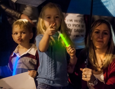 Holly Hall waits for her husband, 14th Airlift Squadron pilot Captain Matthew Hall, to exit the plane, along with her children Cooper, Cailyn and Kallie (not pictured) at Joint Base Charleston — Air Base, S.C. on November 2, 2013. (U.S. Air Force photo/Airman 1st Class Michael Reeves)