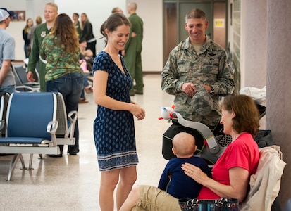 Sarah Hanks, wife of Senior Master Sgt. Justus Hanks, 437th Operations Support Squadron Aircrew Flight Equipment superintendent and Chief Master Sgt. Shawn Hughes, 437th Airlift Wing command chief, share a laugh with baby, Noah Hanks, while awaiting the return of Sarah’s husband November 2, 2013 at Joint Base Charleston — Air Base, S.C. SMSgt Hanks was deployed with the 14th Airlift Squadron. (U.S. Air Force photo/Airman 1st Class Michael Reeves)