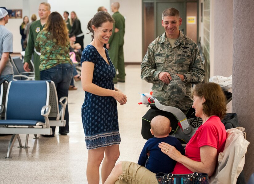 Sarah Hanks, wife of Senior Master Sgt. Justus Hanks, 437th Operations Support Squadron Aircrew Flight Equipment superintendent and Chief Master Sgt. Shawn Hughes, 437th Airlift Wing command chief, share a laugh with baby, Noah Hanks, while awaiting the return of Sarah’s husband November 2, 2013 at Joint Base Charleston — Air Base, S.C. SMSgt Hanks was deployed with the 14th Airlift Squadron. (U.S. Air Force photo/Airman 1st Class Michael Reeves)