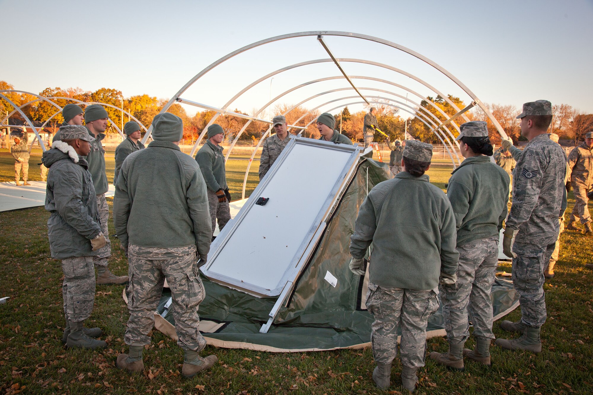Senior Airman Matthew Satterlie, 934th Civil Engineering Squadron, instructs how to install the door panel on an Alaska tent. Members of the 934 CES and 934th Force Support Squadron practiced setting up and tearing down the shelters during the November Unit Training Assembly weekend at the Minneapolis-St. Paul Air Reserve Station, Minn.  (U.S. Air Force photo/Shannon McKay)