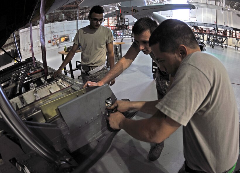 Airmen from the 317th Maintenance Squadron inspect one of the ramp hooks on a C-130J Oct. 30, 2013, at Dyess Air Force Base, Texas. The cargo ramp hooks are the primary means for securing the cargo ramp against the fuselage. (U.S. Air Force photo by Airman 1st Class Kedesha Pennant/Released)

