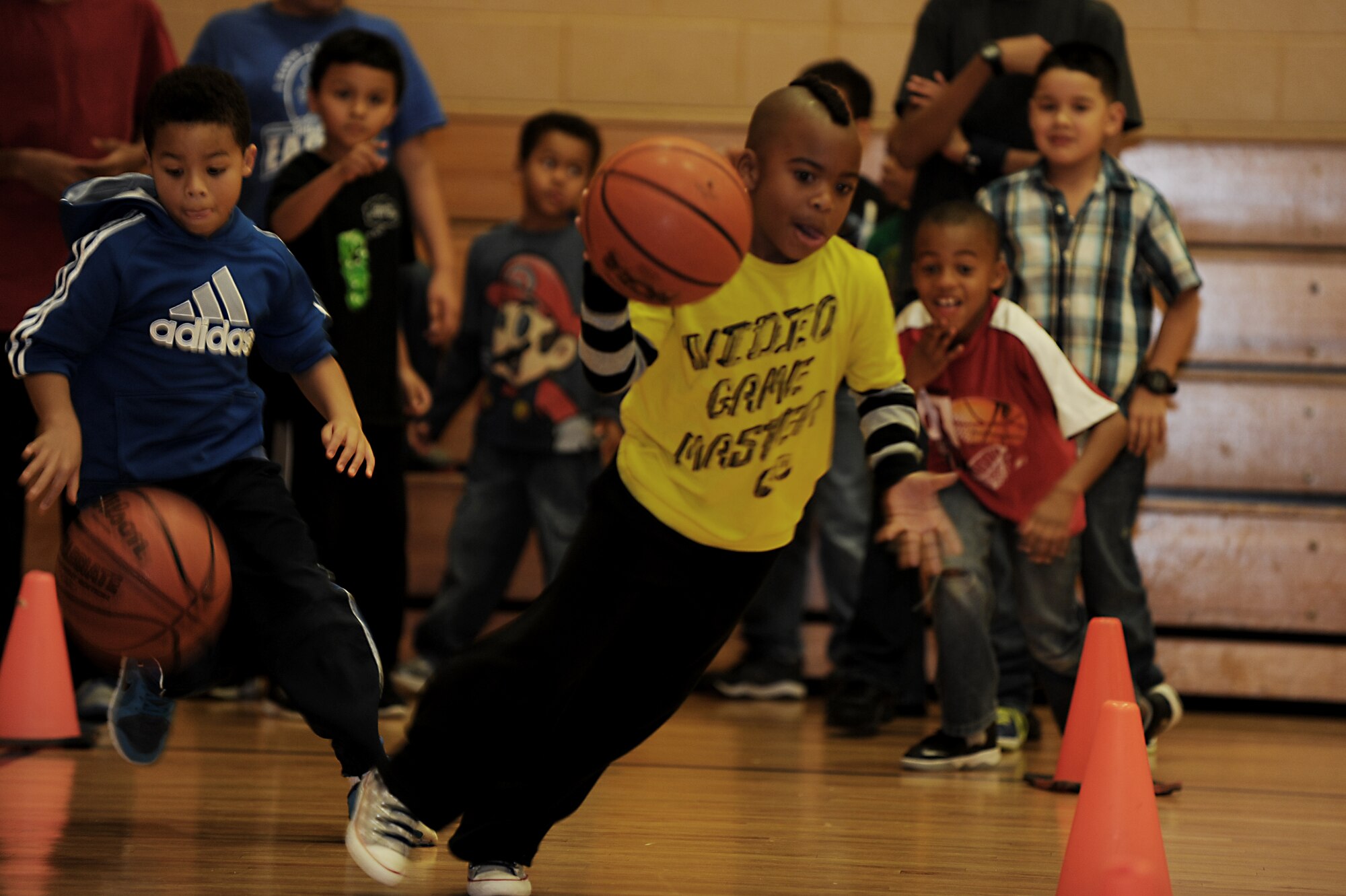 Two Joint Base Langley-Eustis children race to dribble basketballs through obstacles during the Joint Base Langley-Eustis Youth Program’s Triple Play event at the Bethel Manor Youth Center in Yorktown, Va., Nov. 5, 2013. The race was held to boost physical activity and improve healthy interactions between participants. (U.S. Air Force photo by Staff Sgt. Jarad A. Denton/Released)