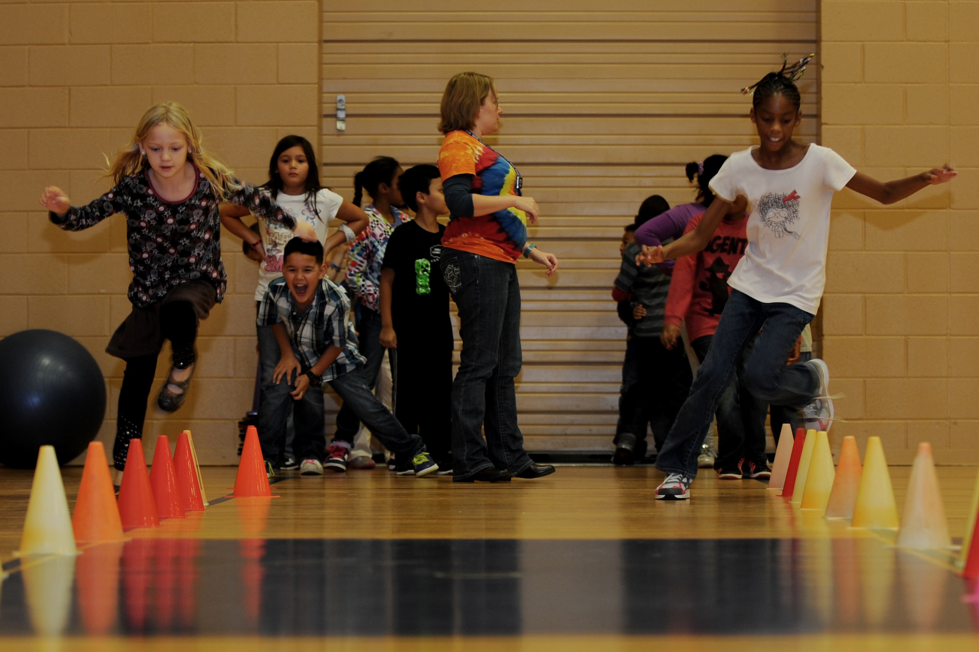 Two Joint Base Langley-Eustis children run through a cone obstacle course during the Joint Base Langley-Eustis Youth Program’s Triple Play event at the Bethel Manor Youth Center in Yorktown, Va., Nov. 5, 2013. Triple Play is designed to improve children’s knowledge of healthy eating habits, good nutrition and physical fitness. (U.S. Air Force photo by Staff Sgt. Jarad A. Denton/Released)
