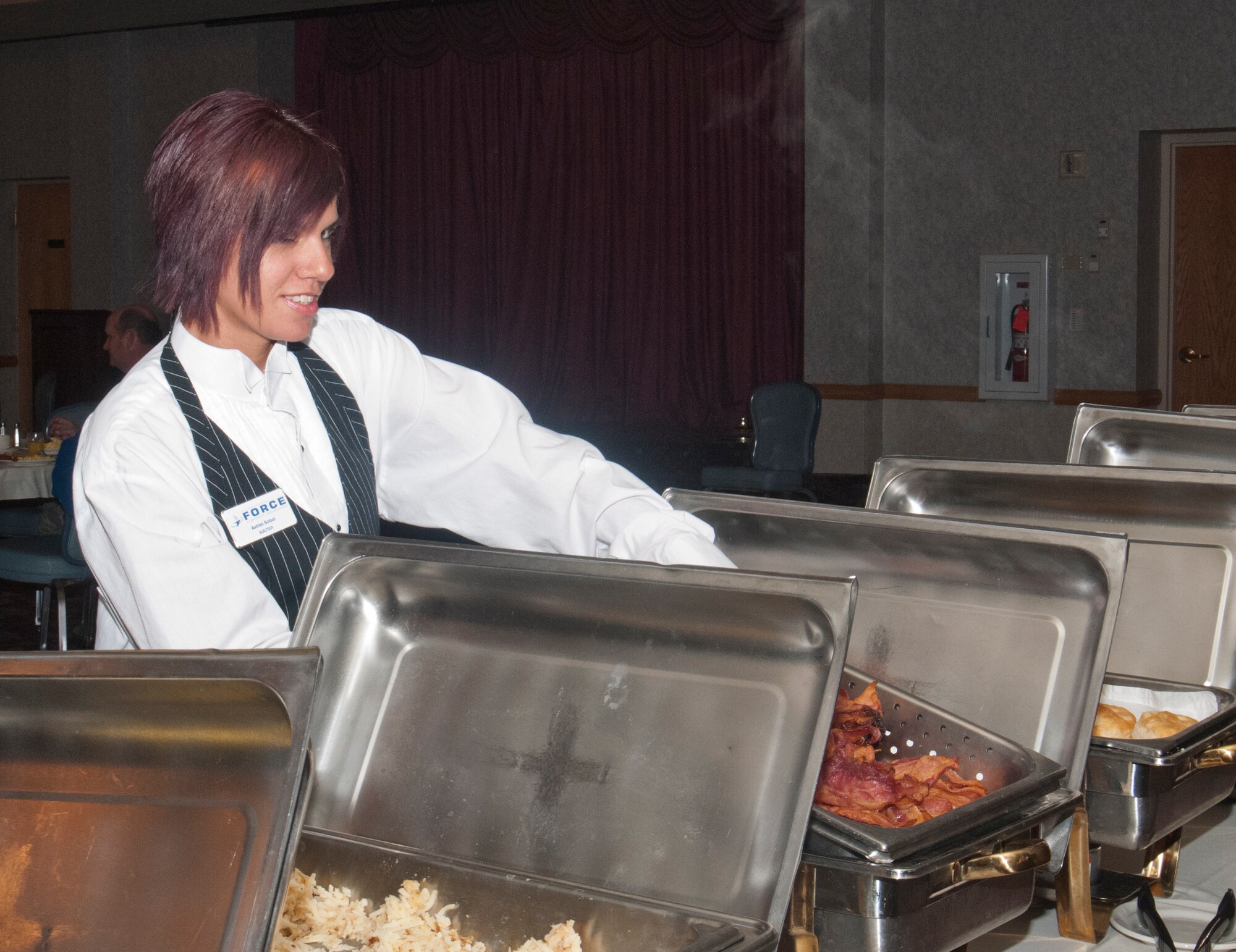 Ashlei Sobol, Trail’s End Club waitress, brings out food for attendees of the club’s membership appreciation breakfast Nov. 5, 2013. The club’s staff intends to host an appreciation meal once a month. (U.S. Air Force photo by Airman 1st Class Jason Wiese)